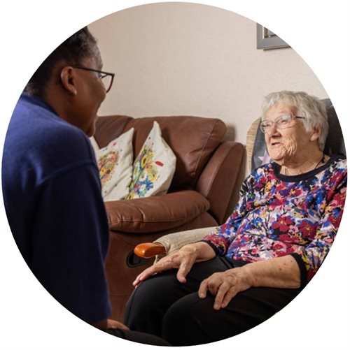 An older woman chatting to a carer